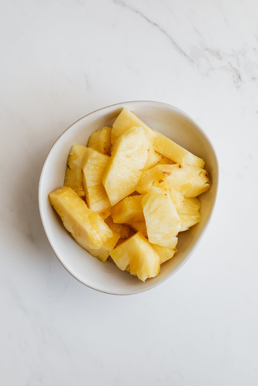 bowl of fresh sliced pineapple on table